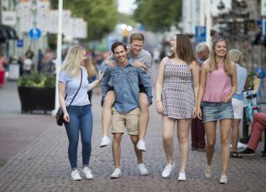 Unga och glada människor går på Torggatan i Mariehamn.