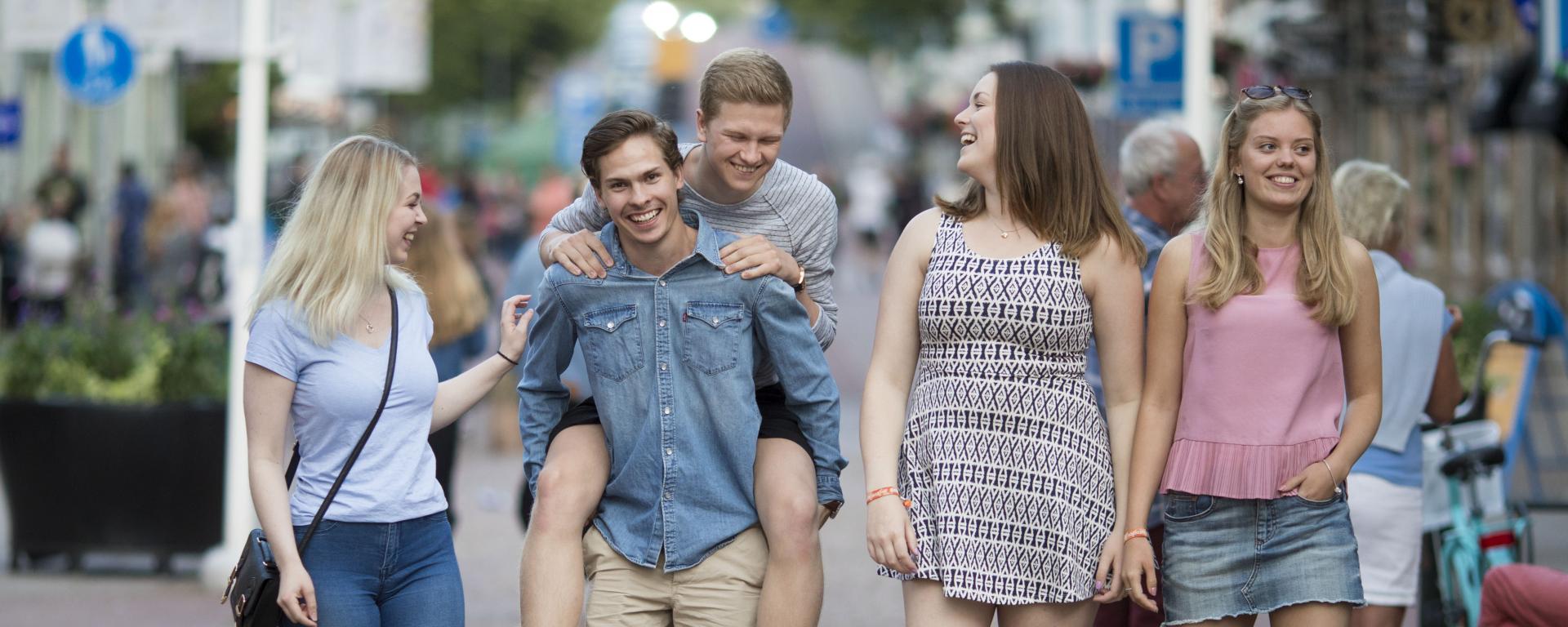 Unga och glada människor går på Torggatan i Mariehamn.