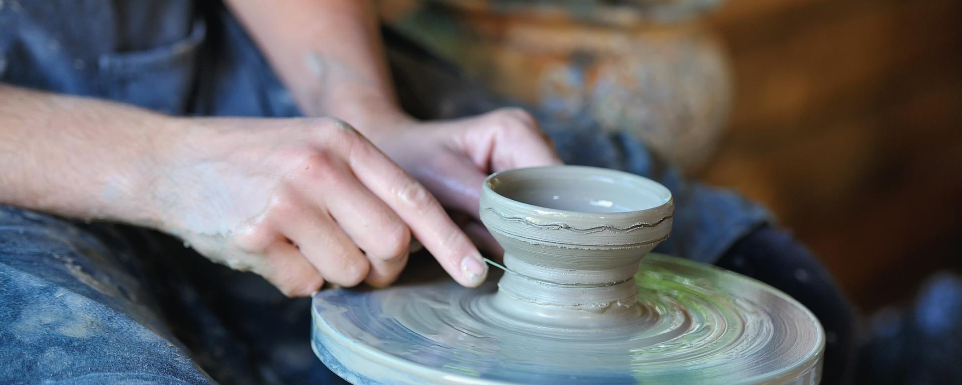 Händer som drejar keramik.