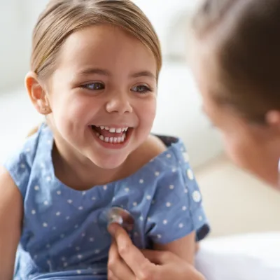 Glad flicka med läkare vid barnrådgivningen.